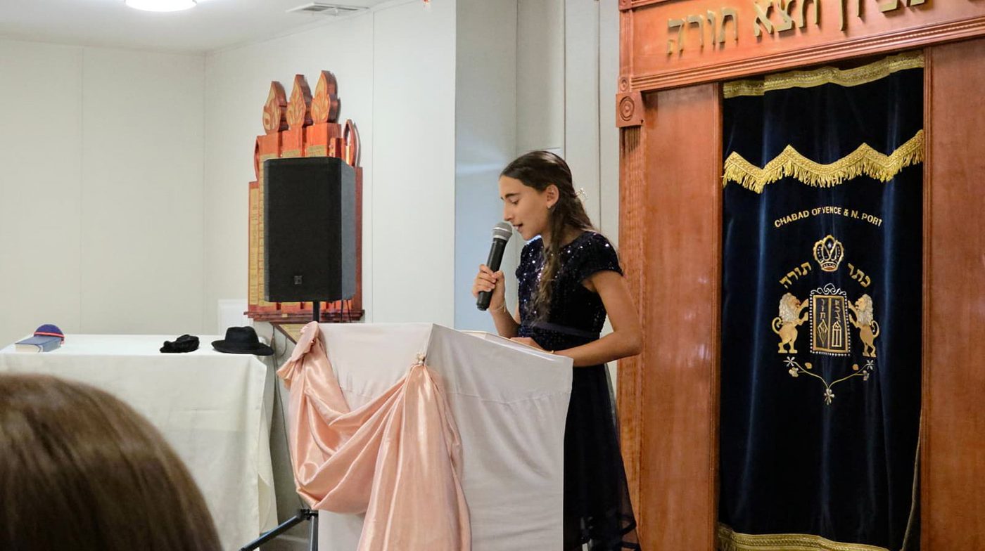 A bat mitzvah speech at Chabad of Venice, beside the Aron Kodesh