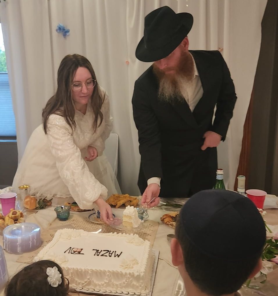 Rafael and Rivka cutting the Mazal Tov cake
