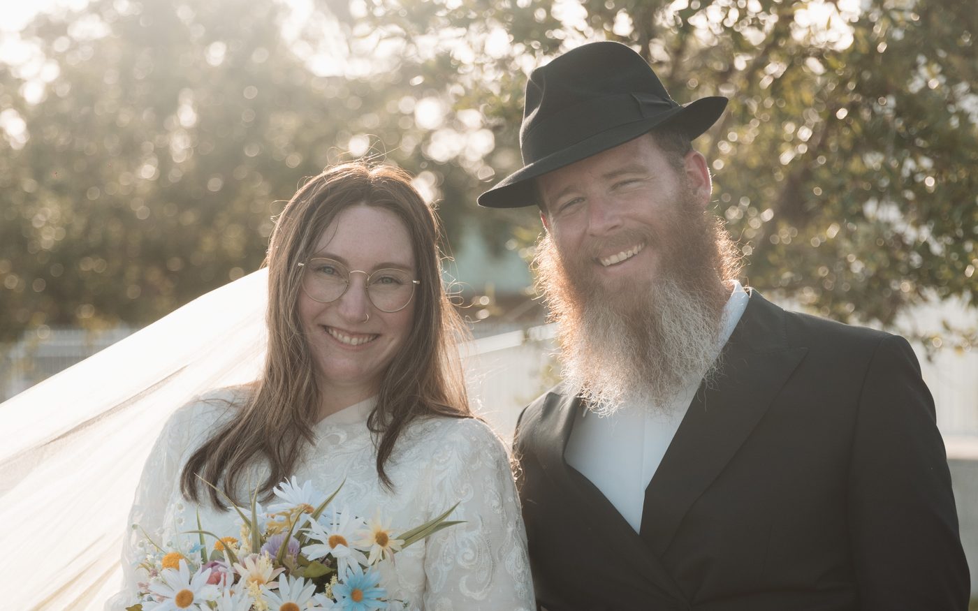 Rafael and Rivka Drago on their wedding day, the bride holding her bouquet