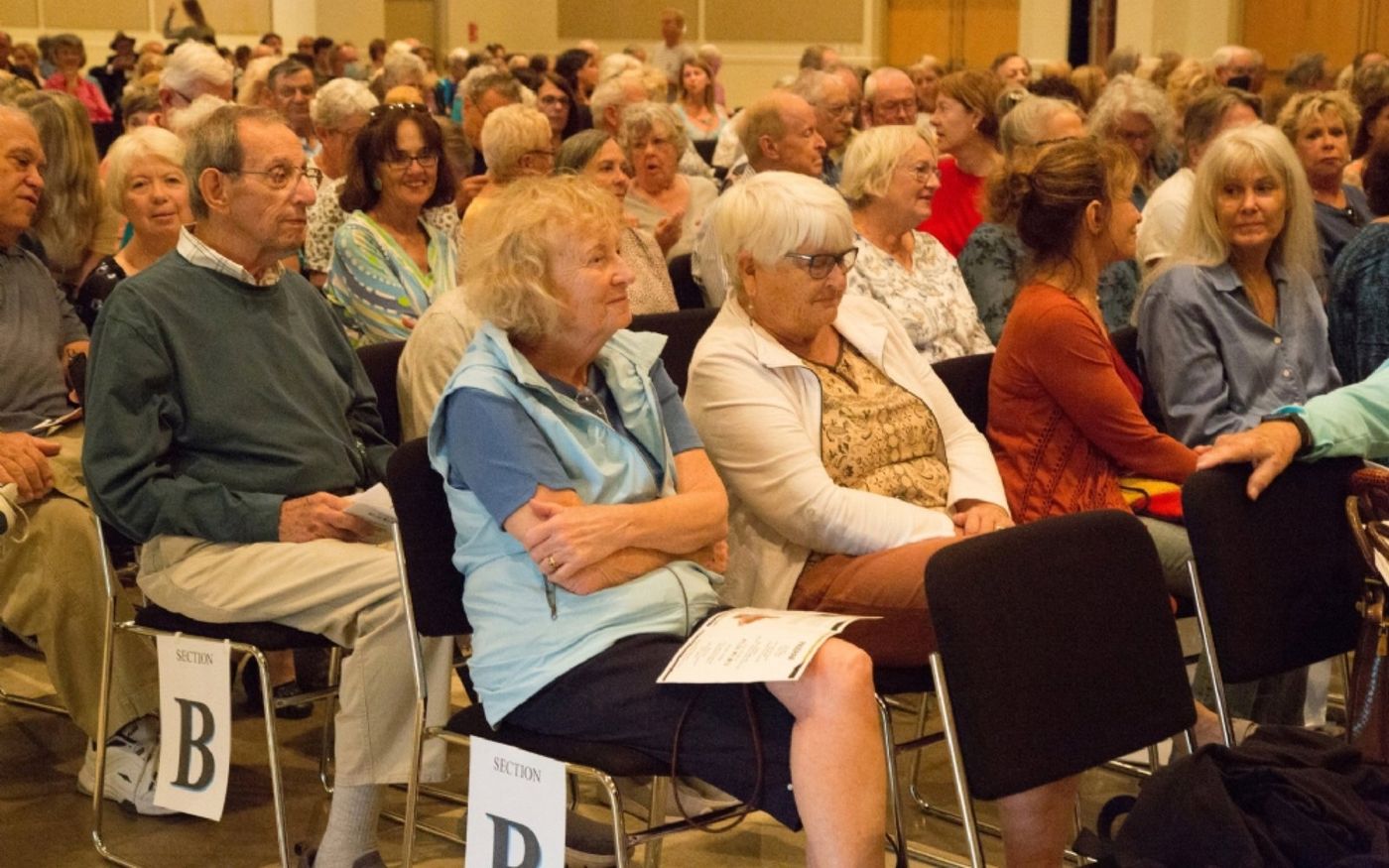 Community members seated and listening intently during the program