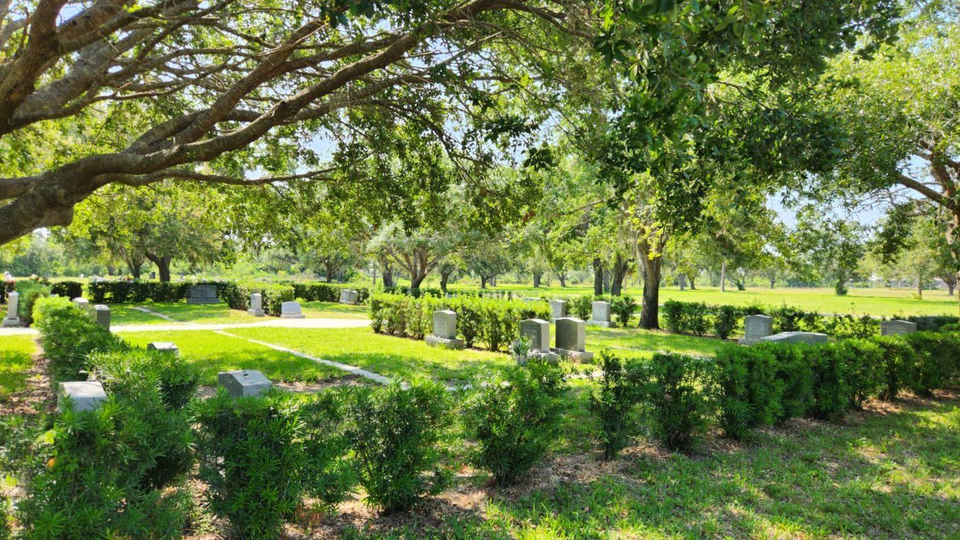 The Jerusalem Gardens Jewish section at Venice Memorial Gardens, with headstones set among hedges beneath mature oak trees