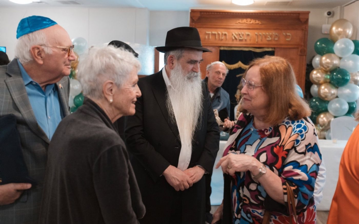 Community members greeting Rabbi Sholom warmly at a Chabad of Venice holiday gathering